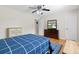 Bedroom features wood laminate flooring, ceiling fan, closet, and television at 487 Waterloo Ct, Spring Hill, FL 34609