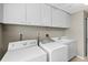 Bright laundry room featuring a washer, dryer, sink, and ample cabinet storage at 487 Waterloo Ct, Spring Hill, FL 34609