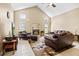 Spacious living room showcasing vaulted ceilings and a cozy fireplace with brown, comfortable-looking furniture at 487 Waterloo Ct, Spring Hill, FL 34609
