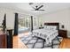Bright main bedroom with pool views from sliding glass doors, ceiling fan, and wood laminate flooring at 487 Waterloo Ct, Spring Hill, FL 34609