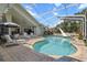 Screened-in pool with a slide, sun loungers, and an outdoor dining area at 487 Waterloo Ct, Spring Hill, FL 34609