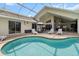 Sparkling pool with sun loungers and an umbrella, perfect for relaxing outdoors at 487 Waterloo Ct, Spring Hill, FL 34609