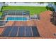 Aerial view of a screened-in pool and backyard, highlighted by solar panels on the roof at 4923 Fort Peck Rd, New Port Richey, FL 34655