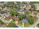 Aerial view of home in a lovely neighborhood with mature trees and a nearby pond at 4923 Fort Peck Rd, New Port Richey, FL 34655