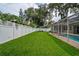 Spacious backyard offers a screened-in pool and expansive lawn, perfect for outdoor entertaining and relaxation at 4923 Fort Peck Rd, New Port Richey, FL 34655