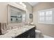 Stylish bathroom featuring a granite countertop, large mirror, modern fixtures, and a window with shutters at 4923 Fort Peck Rd, New Port Richey, FL 34655