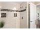Shower showcasing neutral tile, mosaic accents, niche storage, and glass door at 4923 Fort Peck Rd, New Port Richey, FL 34655