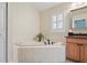 Bright bathroom showcasing a tiled tub with black hardware and a window with plantation shutters at 4923 Fort Peck Rd, New Port Richey, FL 34655