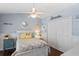 Cozy bedroom with light blue walls, decorative pillows, closet, ceiling fan, and stylish décor at 4923 Fort Peck Rd, New Port Richey, FL 34655