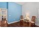 Cozy bedroom with blue accent wall, hardwood floors, with two wooden chairs and view to another bedroom at 4923 Fort Peck Rd, New Port Richey, FL 34655