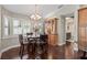 Charming dining area with dark wood floors, modern chandelier, and plantation shutters for lots of natural light at 4923 Fort Peck Rd, New Port Richey, FL 34655