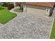 Paver driveway leading to a two-car garage, framed by well-maintained landscaping and a manicured lawn at 4923 Fort Peck Rd, New Port Richey, FL 34655