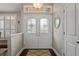 Bright foyer with decorative glass double doors, hardwood floors, a decorative mirror, and neutral paint at 4923 Fort Peck Rd, New Port Richey, FL 34655