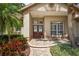 Inviting entryway with double doors, decorative glass, mature landscaping, and a welcoming front porch at 4923 Fort Peck Rd, New Port Richey, FL 34655