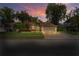 Beautiful single-story home with mature trees, a brick-paved driveway, and well-lit exterior at 4923 Fort Peck Rd, New Port Richey, FL 34655