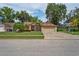 Charming single-story home with a well-manicured lawn, lush landscaping, and brick-paved driveway at 4923 Fort Peck Rd, New Port Richey, FL 34655