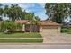 Beautifully landscaped single Gathering home featuring a manicured lawn, a brick paved driveway and mature trees at 4923 Fort Peck Rd, New Port Richey, FL 34655