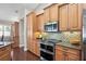 Gourmet kitchen features stainless appliances, double oven, granite countertops and custom backsplash at 4923 Fort Peck Rd, New Port Richey, FL 34655