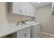 Well-lit laundry room featuring modern white cabinets, a sink, and updated washer and dryer at 4923 Fort Peck Rd, New Port Richey, FL 34655