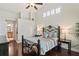Bright main bedroom boasting dark wood floors, an elegant bed frame, and adjacent ensuite bathroom at 4923 Fort Peck Rd, New Port Richey, FL 34655