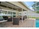 Beautiful screened-in patio with ample seating, overlooking the swimming pool and backyard at 4923 Fort Peck Rd, New Port Richey, FL 34655