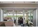 A well-appointed patio with outdoor seating overlooks a sparkling pool and lush backyard through sliding glass doors at 4923 Fort Peck Rd, New Port Richey, FL 34655