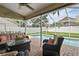 Relaxing screened-in patio with comfortable outdoor seating that overlooks the sparkling swimming pool and backyard at 4923 Fort Peck Rd, New Port Richey, FL 34655