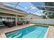 Beautiful in-ground swimming pool with outdoor seating, perfect for relaxing and entertaining guests at 4923 Fort Peck Rd, New Port Richey, FL 34655