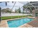 Screened-in pool area with brick-paved patio offers a refreshing escape and backyard view at 4923 Fort Peck Rd, New Port Richey, FL 34655