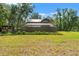 Sprawling backyard featuring a screened pool enclosure, lush greenery, and mature trees at 5363 Utopia Pl, Brooksville, FL 34601