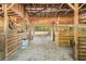 Rustic barn interior with wooden beams, stalls, and a dirt floor providing a functional agricultural space at 5363 Utopia Pl, Brooksville, FL 34601