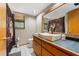 Bathroom featuring a modern sink, wooden-framed mirror, and tiled floors, offering a clean and stylish design at 5363 Utopia Pl, Brooksville, FL 34601