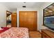 Cozy bedroom with an attached closet, TV, and open door leading to a living room at 5363 Utopia Pl, Brooksville, FL 34601