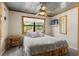 Cozy bedroom featuring a unique metal ceiling, natural light from the window, and a ceiling fan at 5363 Utopia Pl, Brooksville, FL 34601