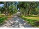 View of a rustic road leading up to a secluded home enveloped in lush greenery at 5363 Utopia Pl, Brooksville, FL 34601