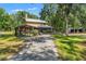 Inviting home exterior showcasing a covered porch and a scenic wooded backdrop at 5363 Utopia Pl, Brooksville, FL 34601