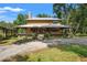 Charming two-story wooden home with a metal roof and a welcoming wrap-around porch surrounded by lush greenery at 5363 Utopia Pl, Brooksville, FL 34601