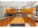 U-shaped kitchen with wooden cabinets, modern appliances, and butcher block topped island at 5363 Utopia Pl, Brooksville, FL 34601
