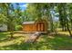 Wood outbuilding with double doors and a wooden walkway surrounded by greenery at 5363 Utopia Pl, Brooksville, FL 34601