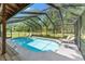 Enclosed in-ground pool surrounded by a screened enclosure and patio furniture offering a private and relaxing outdoor space at 5363 Utopia Pl, Brooksville, FL 34601