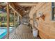 Large screened-in porch with rustic wood floors, ceiling fans, and access to the pool and backyard at 5363 Utopia Pl, Brooksville, FL 34601