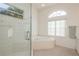 Bathroom featuring a glass shower, soaking tub, and a bright window for natural light and ventilation at 5423 Abagail Dr, Spring Hill, FL 34608
