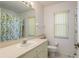 Well-lit bathroom featuring a vanity, sink, toilet, and a shower with a lemon-themed curtain at 5423 Abagail Dr, Spring Hill, FL 34608