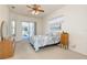 The main bedroom features sliding glass doors to the screened-in pool area and a decorative ceiling fan at 5423 Abagail Dr, Spring Hill, FL 34608