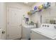 Functional laundry room with a washer, dryer, shelving, and storage space for household essentials at 5423 Abagail Dr, Spring Hill, FL 34608