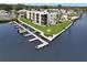 Waterfront condo building with boat docks, manicured lawn, and mature palm trees at 5627 Ferguson Ct # 1303, New Port Richey, FL 34652