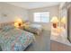 Bright bedroom featuring twin beds with floral bedding, a window with blinds, and a dresser with a mirror at 5627 Ferguson Ct # 1303, New Port Richey, FL 34652