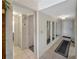 Hallway boasts tiled floors, multiple mirrors, and neutral paint at 5627 Ferguson Ct # 1303, New Port Richey, FL 34652