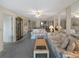 Spacious living room features floral sofas, mirrored wall, ceiling fan, and neutral decor at 5627 Ferguson Ct # 1303, New Port Richey, FL 34652