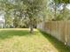 Expansive backyard features a well-maintained lawn bordered by a wooden fence, offering privacy and space at 5701 Brackenwood Dr, Spring Hill, FL 34609